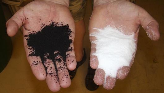 Hände mit Altreifen und Polyethylen-Granulat